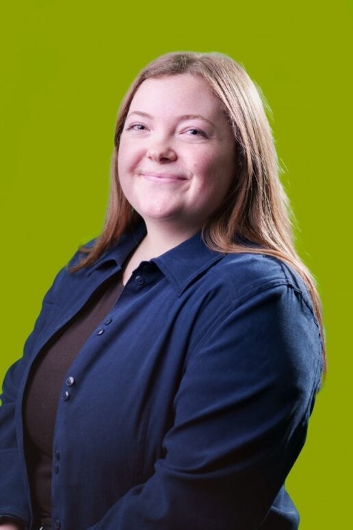 Avery Sudsbury smiling in front of a green background