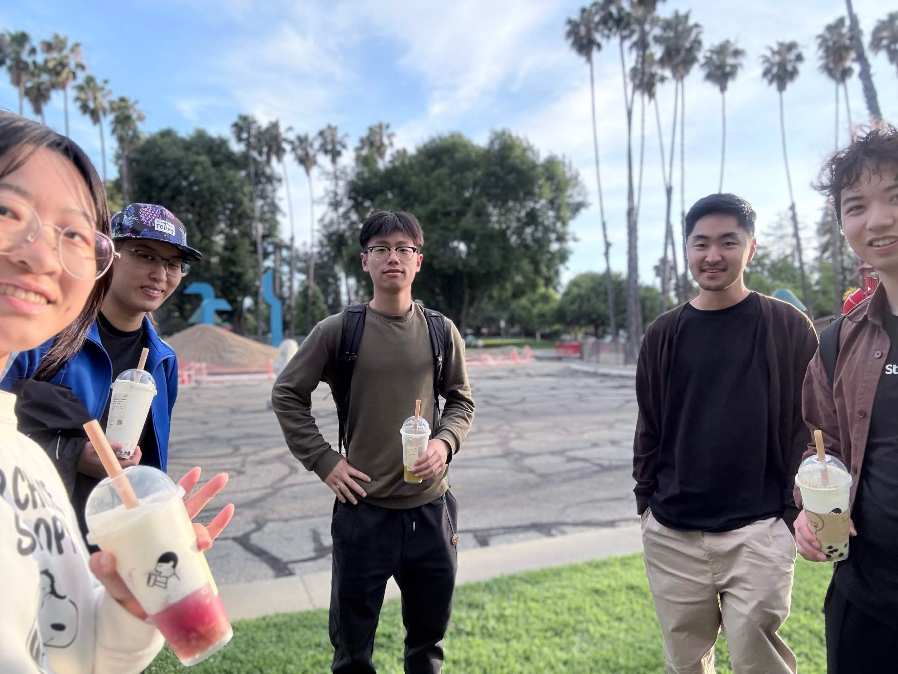 students standing around camera with bubble tea in hand
