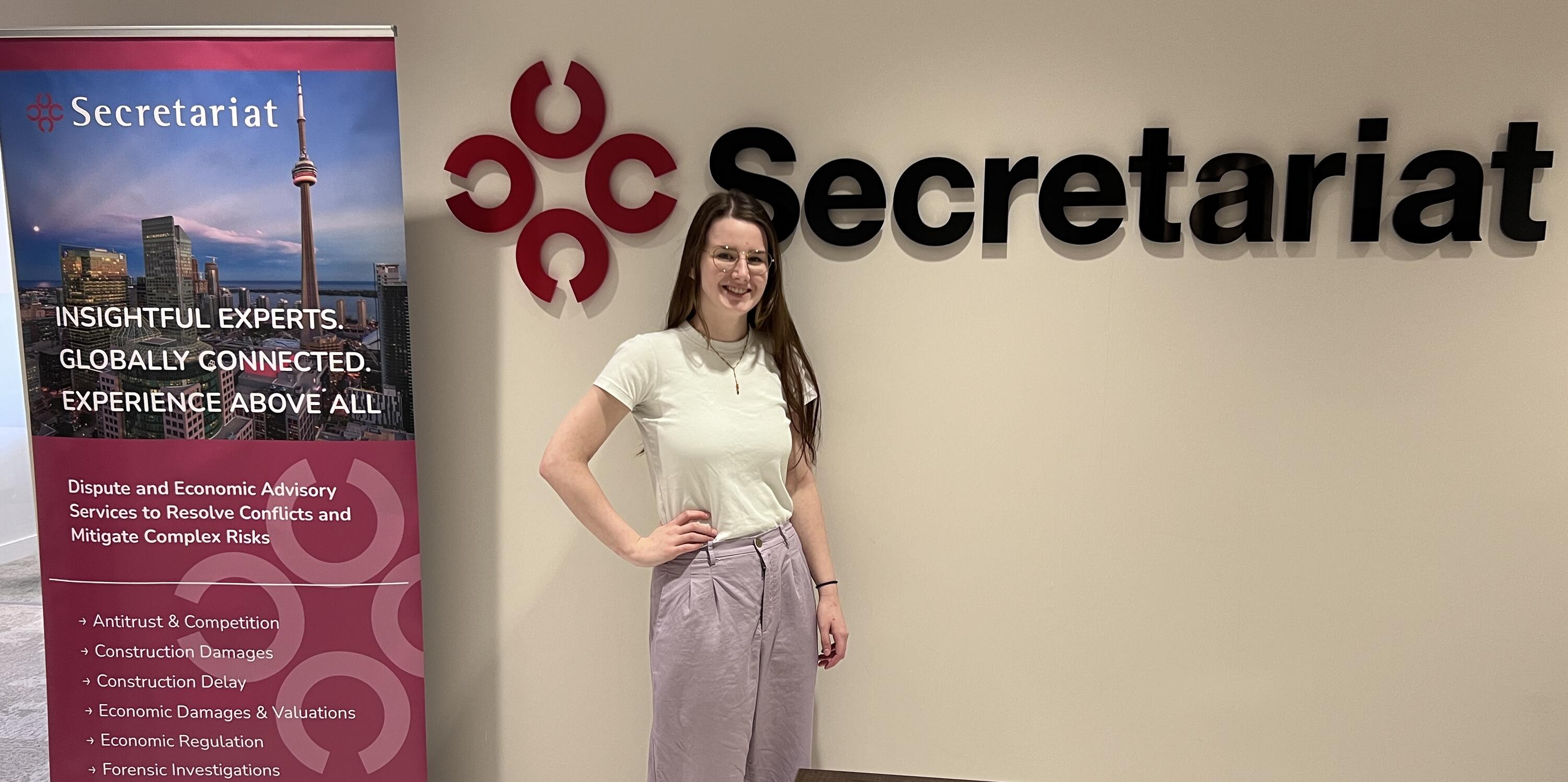 Hannah Teetzel standing in front of Secretariat logo