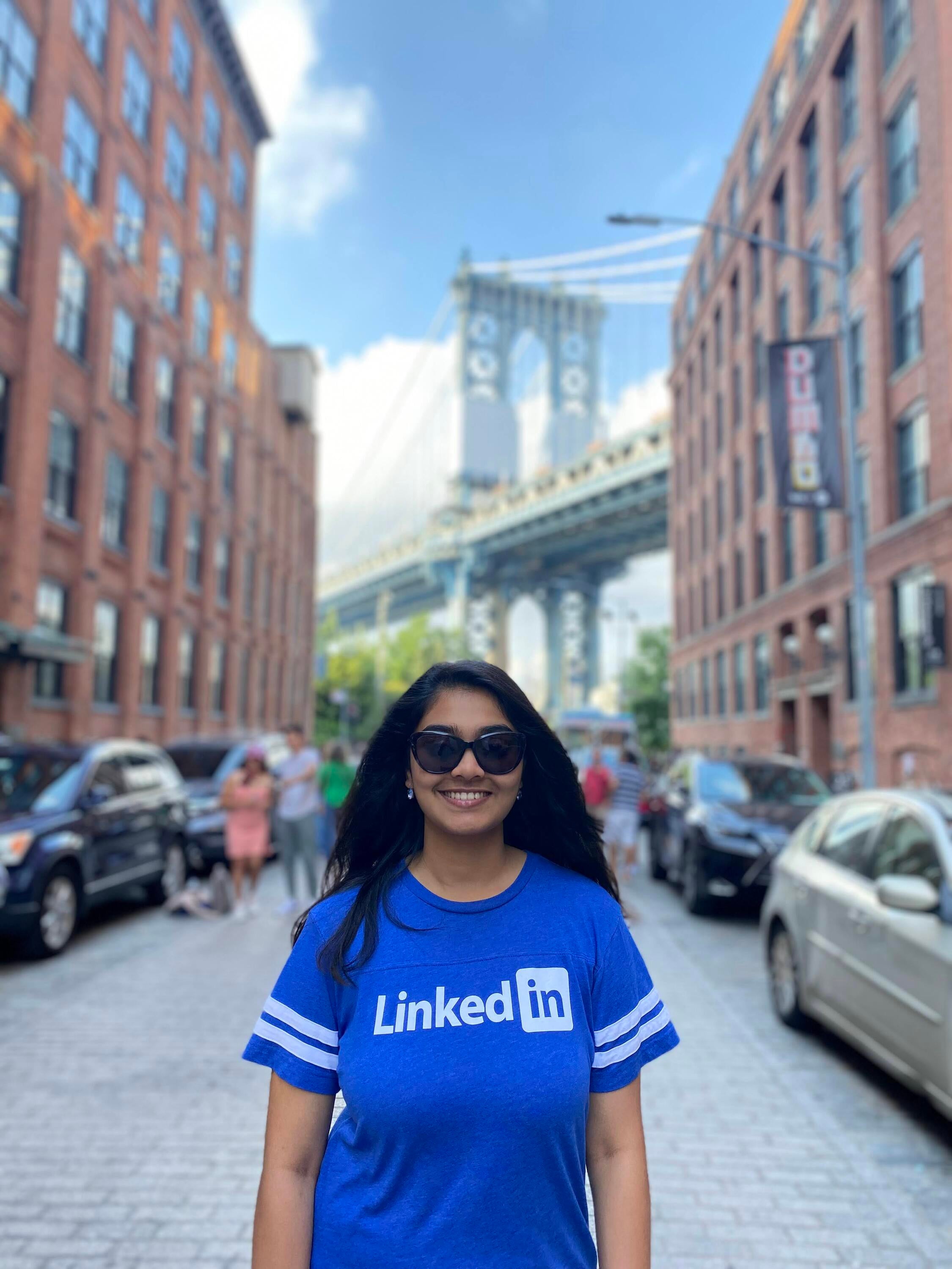 A picture of Yuvika standing in front of the a street with buildings in the background