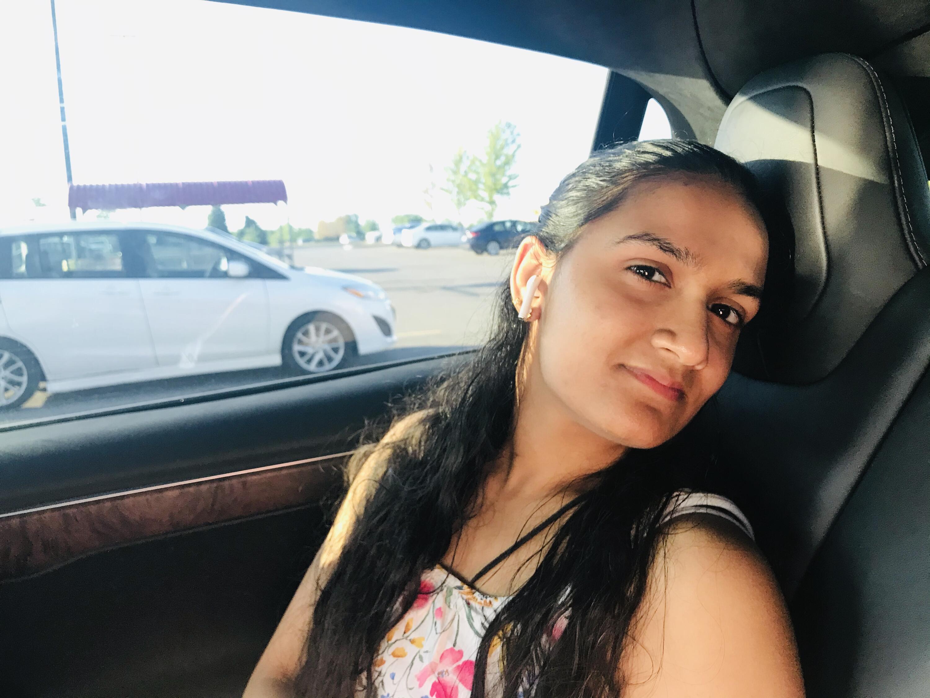 A photo of Navya sitting in a car and smiling. 