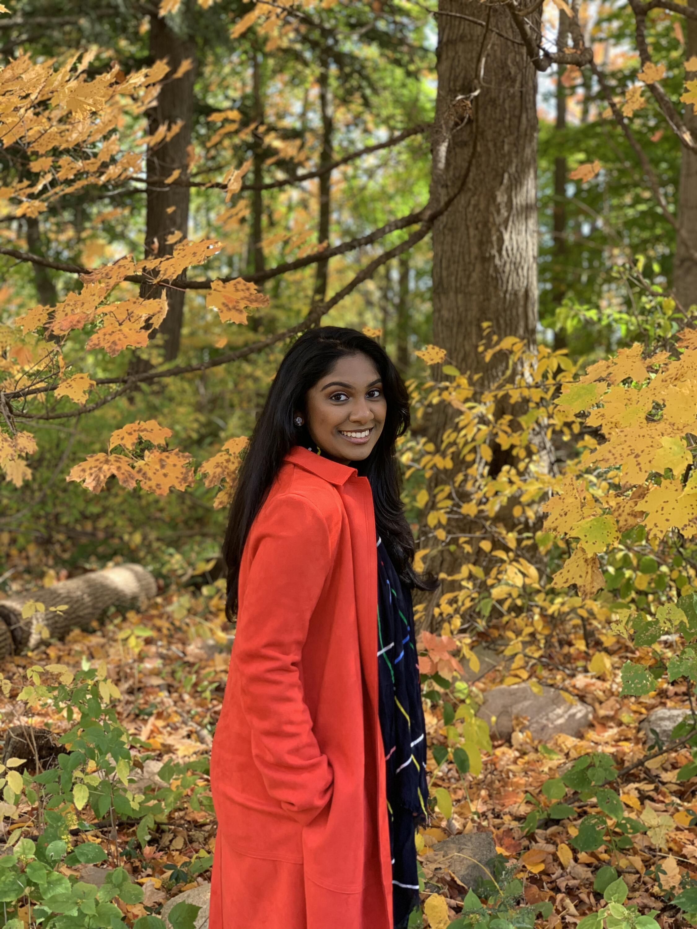 Sophia smiling in the park during the fall. 