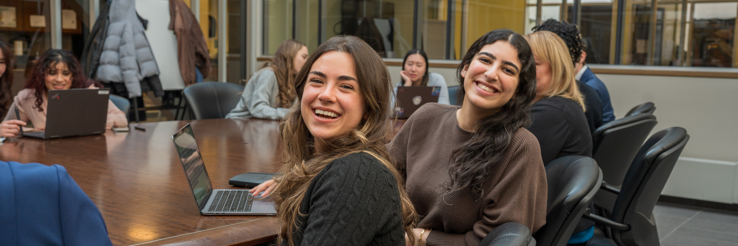 students sitting in a meeting room looking at camera