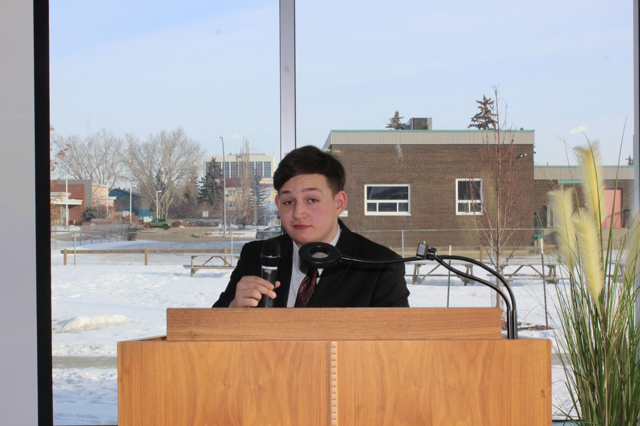 Jordan standing at a podium and holding a microphone