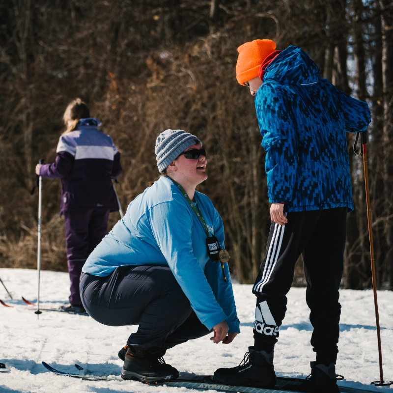 Sarah Alexander fixing a childs' ski boot