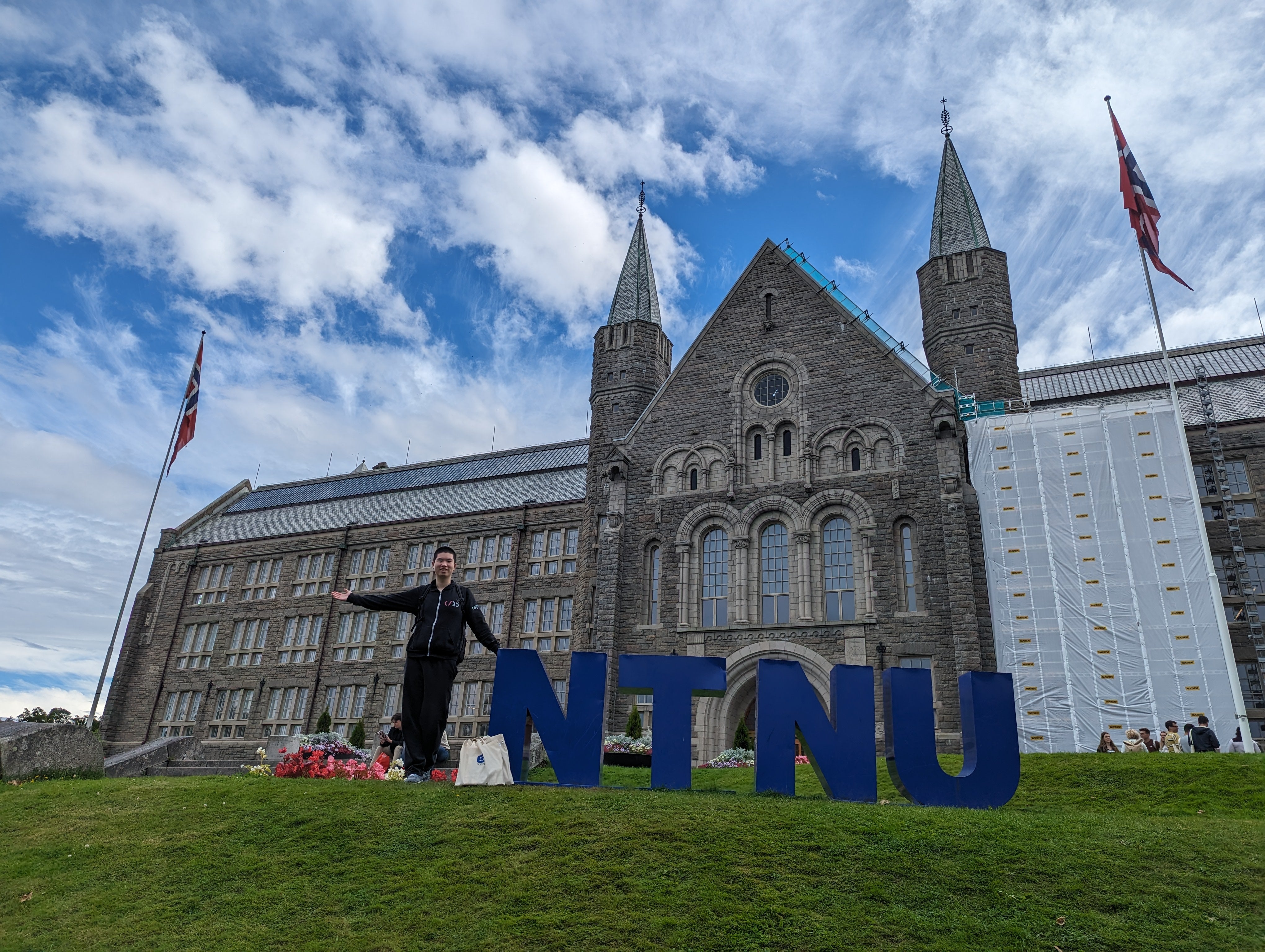 Raymond staying in front of a NTNU sign. 