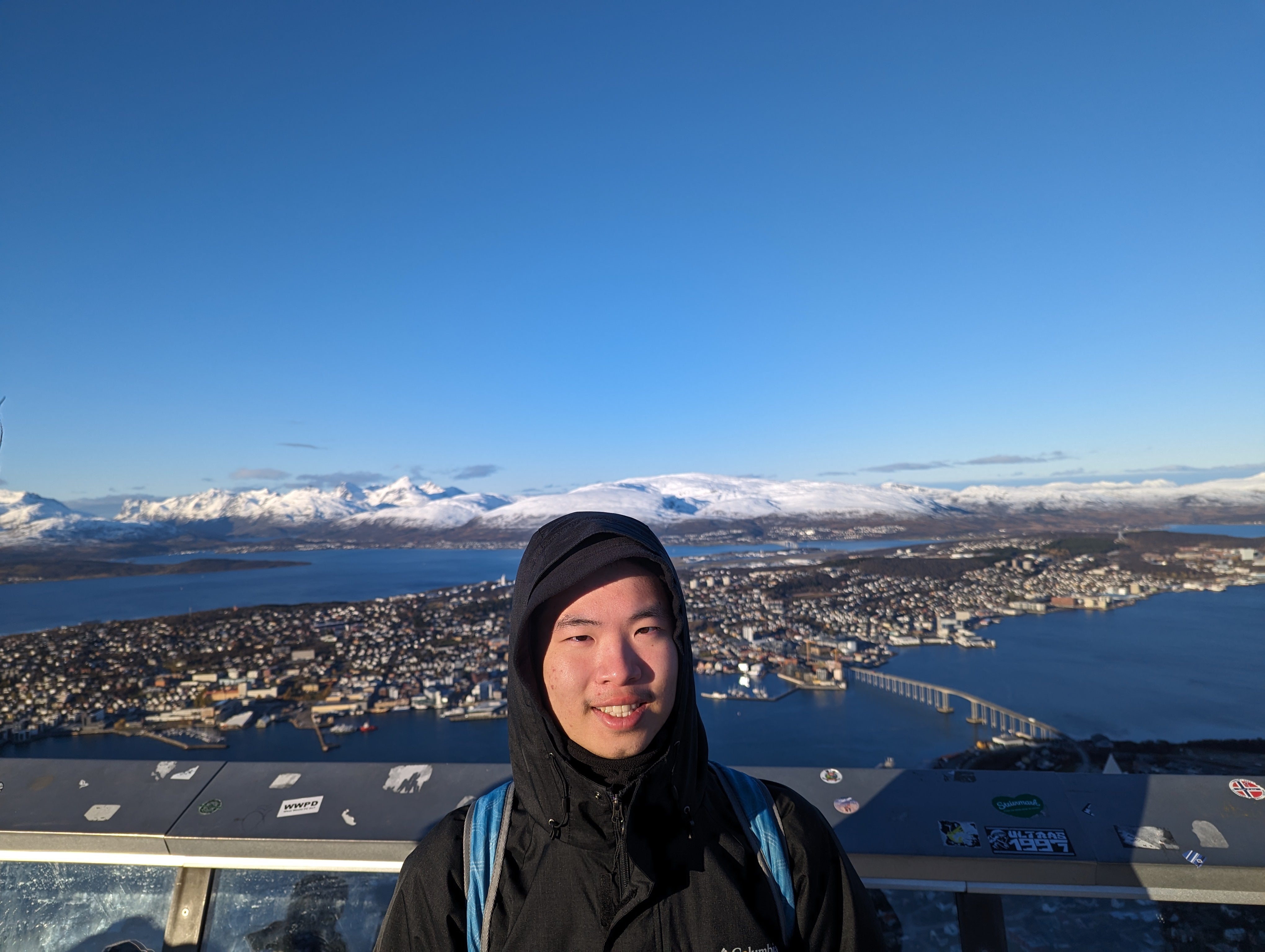 Raymond standing on a balcony over looking a city.