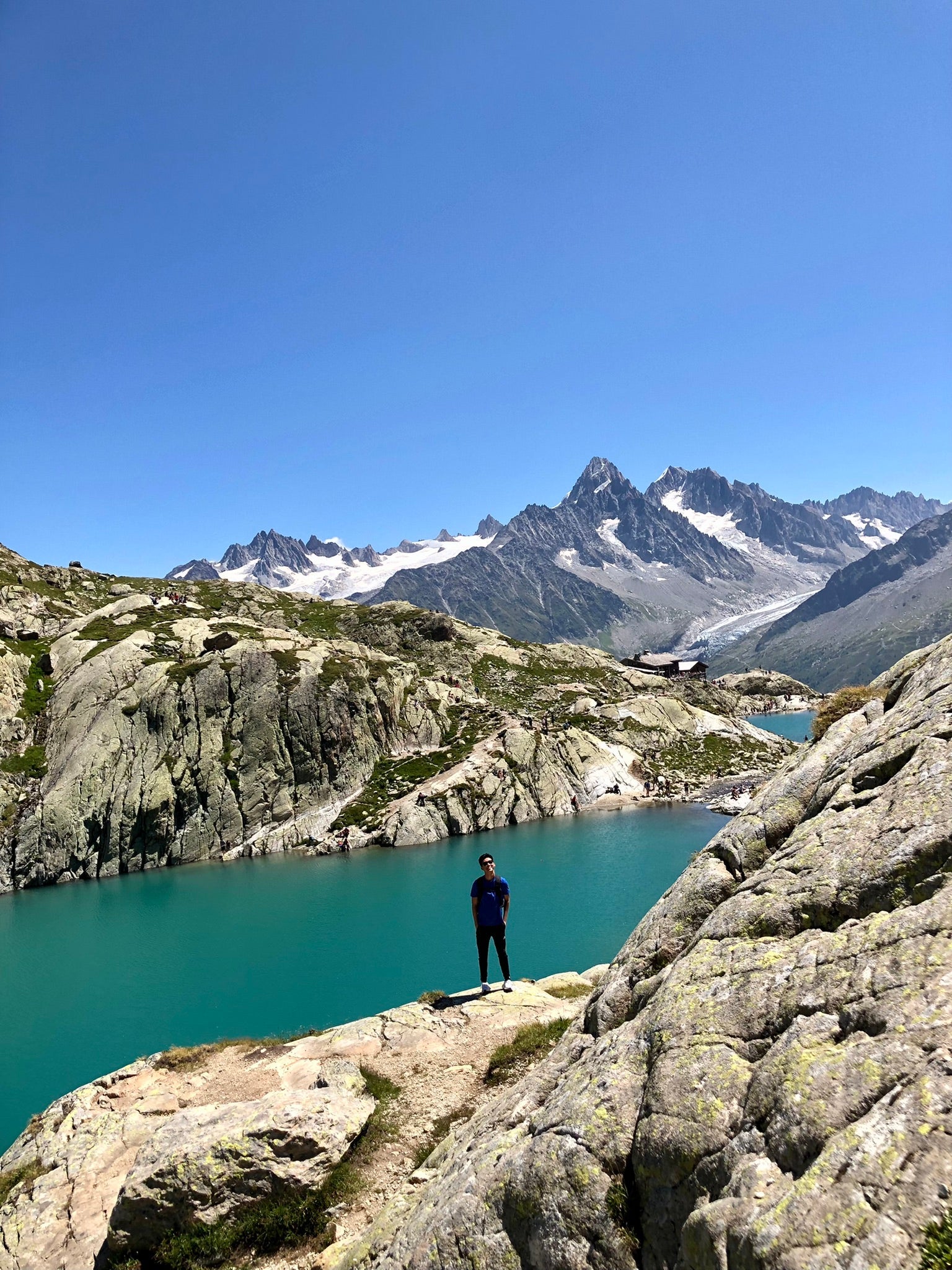 picture of Andrew posing in front of a mountain range and river