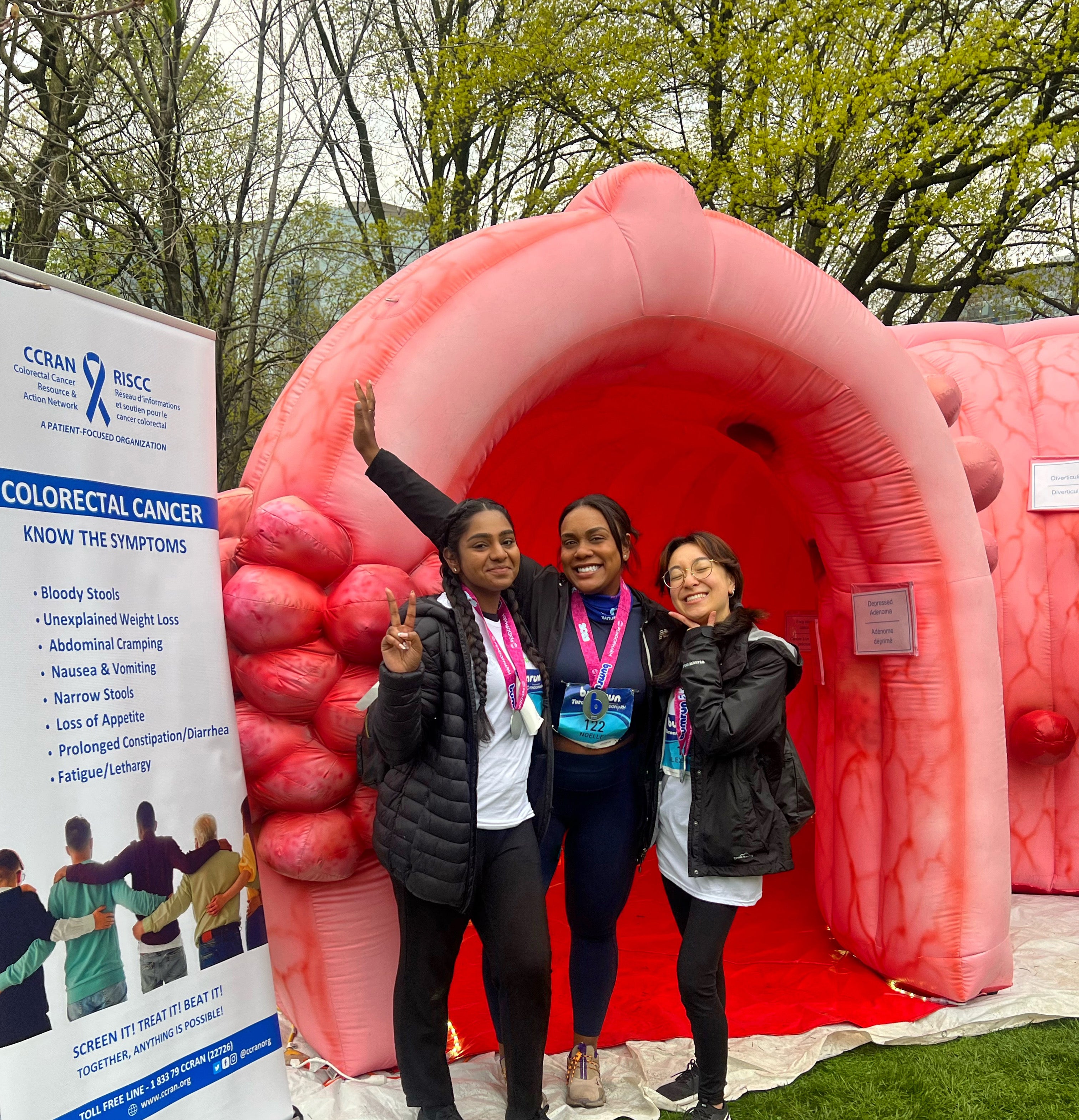 Sharmi and two others standing in front of an inflatable tunnel.