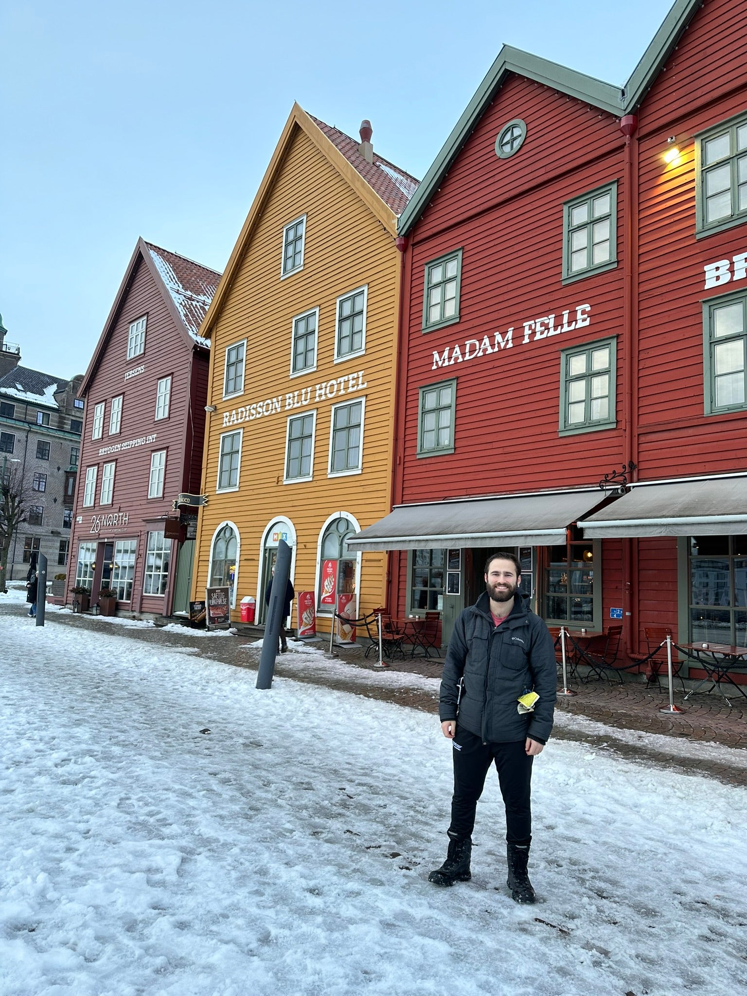 Shawn standing in front of a few colorful buildings.