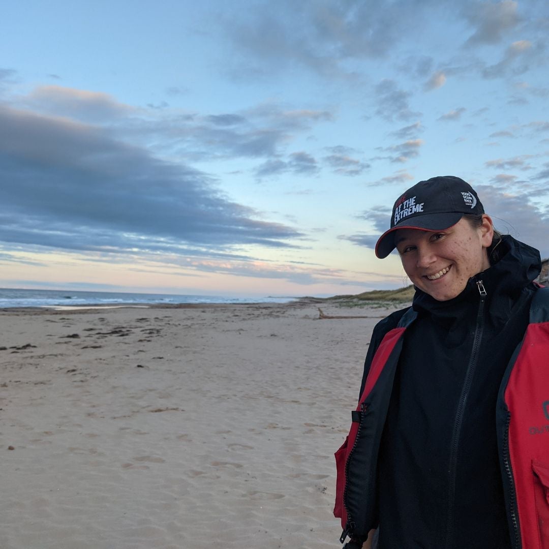 Ashley Ferreira smiling while standing on a beach.