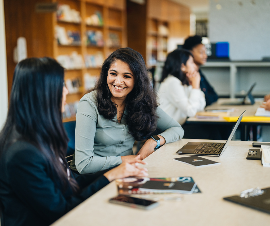 Co-op students smiling in conversation.