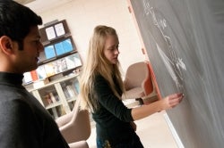 Students writing on a chalk board