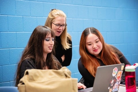 DAC Students looking at a laptop