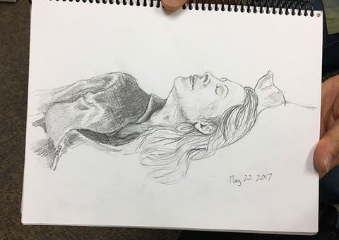 Pencil portrait of a woman lying on a bed