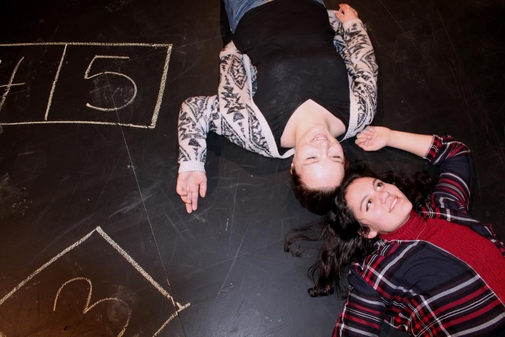 two women lying on floor next to hopscotch grid