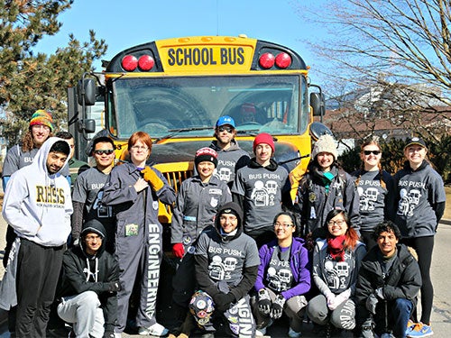 Engineering Society standing in front of a school bus