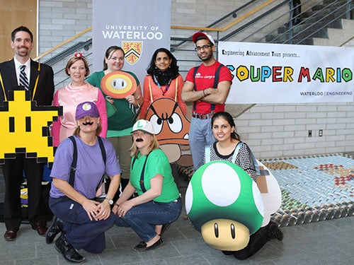 Engineering Advance team posing as Mario game characters in front of their CanBuild structure