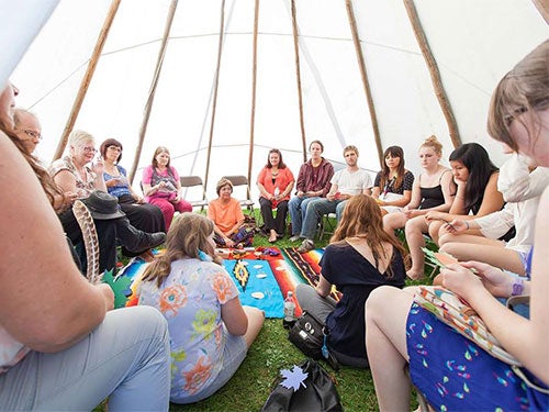 Community members inside a teepee during the annual Pow Wow