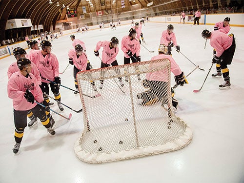 Women's hockey players in pink jerseys