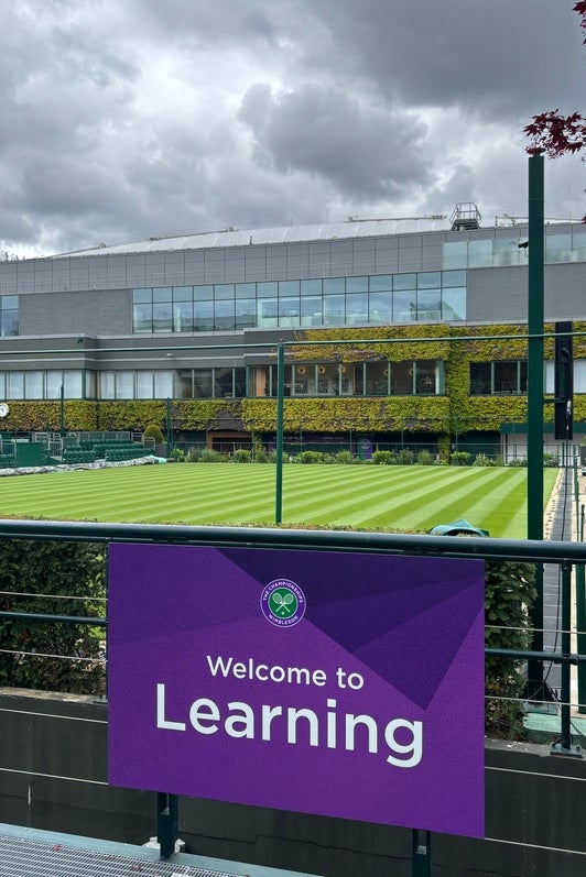 Wimbledon Tennis Court with a sign hanging in front that says welcome to learning