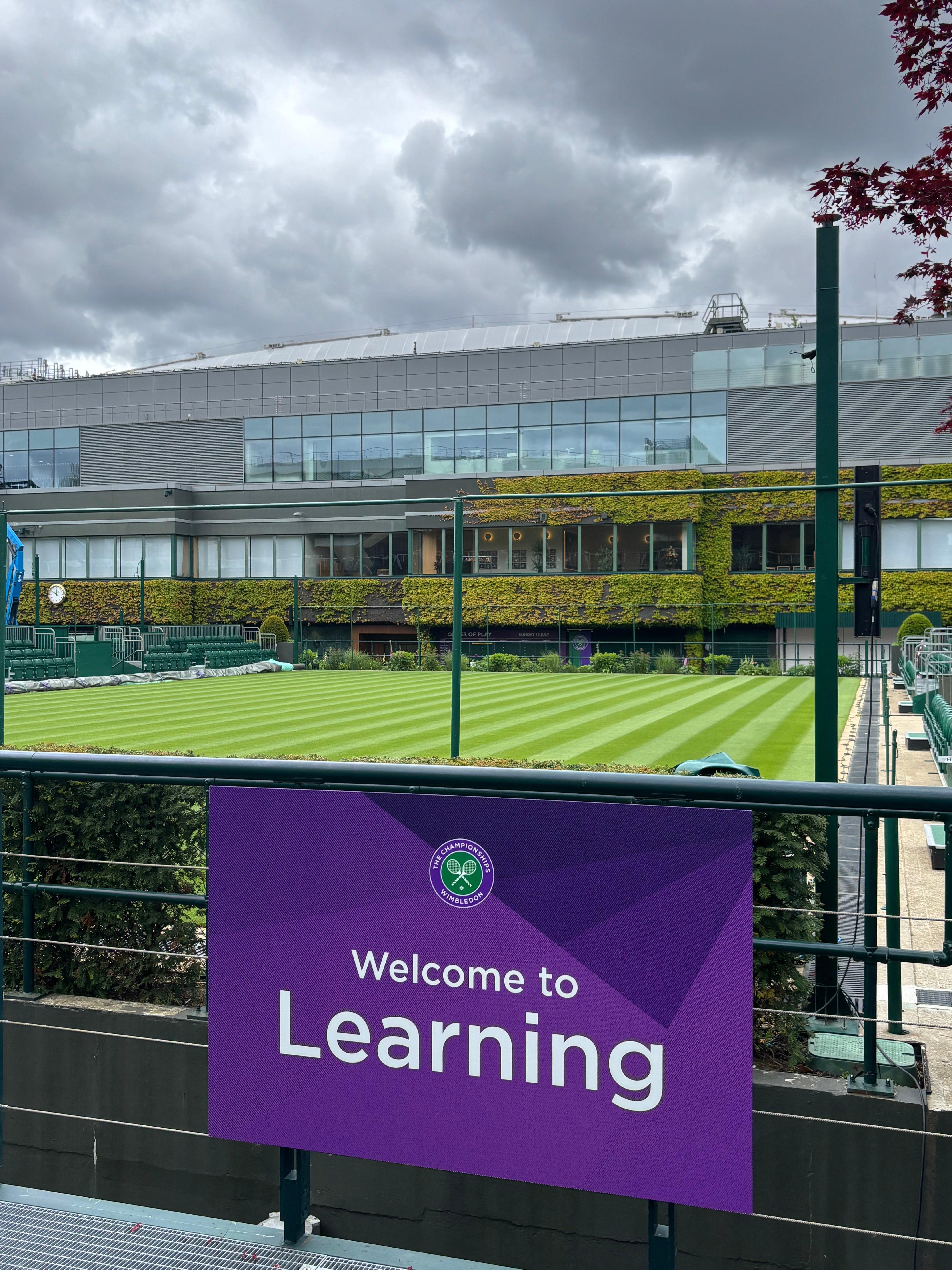 Wimbledon Tennis Court with a sign hanging in front that says welcome to learning