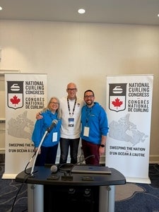 Dr Heather Mair and Simon barrick standing with CEO of Curling Canada Neil Theissen in front of Curling Canada posters