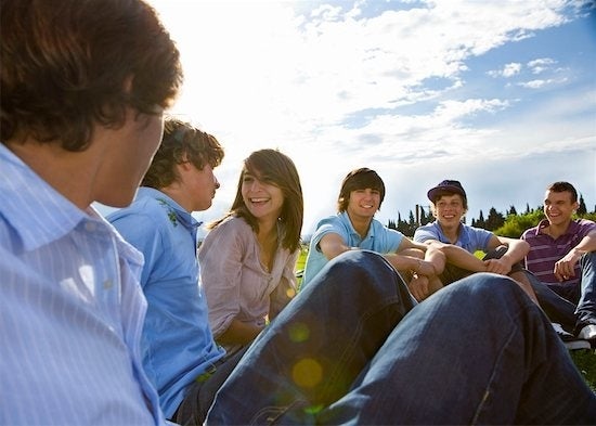 group of teens sitting together outside