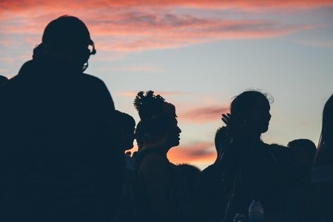 silhouettes of a crowd of people at sunset