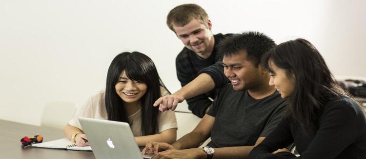 group of students around a laptop