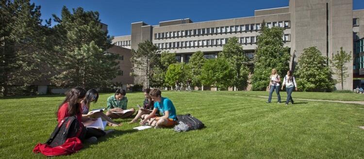 Students sitting on the lawn outside math and computing building