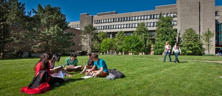 Students sitting on the lawn outside math and computing building