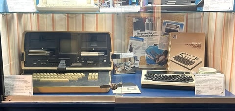 Osborne 1 and TRS-80 Model 100 on display shelf