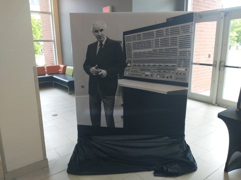 Printed image of Wes Graham standing next to the IBM 360/75 Operations Console