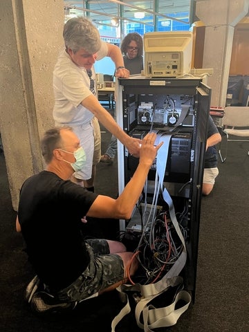 Two people looking inside the PDP 11/04 cabinet