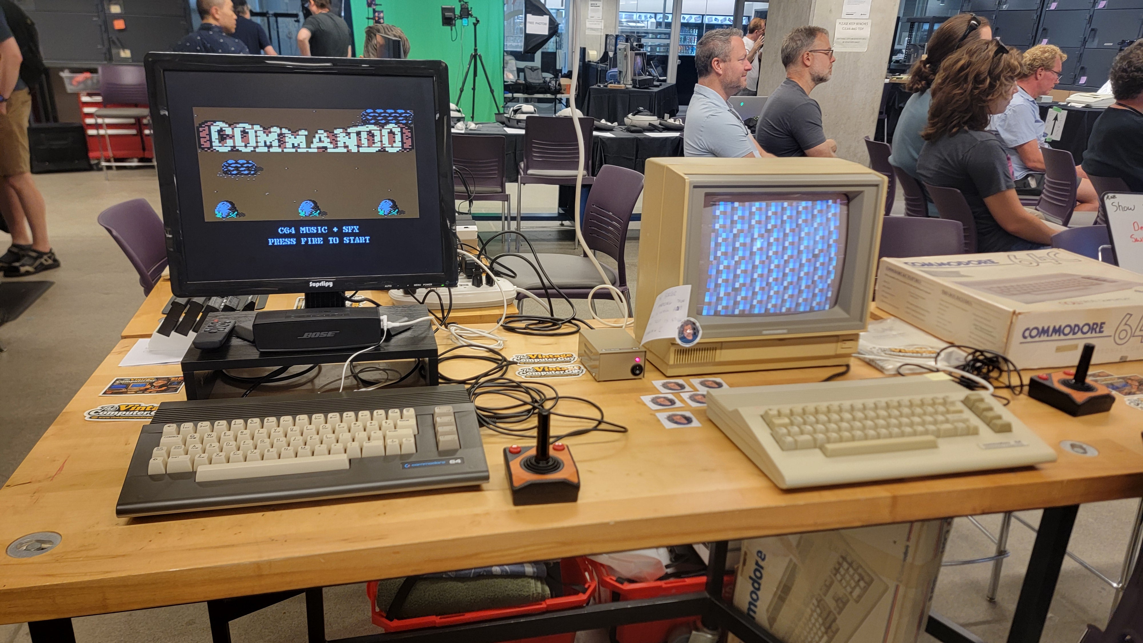 Table with two computers, one is running the video game "COMMANDO".