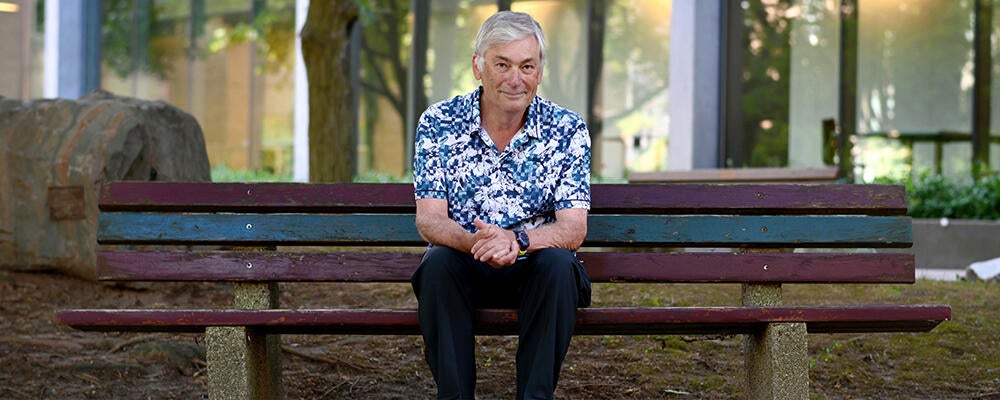 University Professor Ian Munro on bench in Waterloo's rock garden