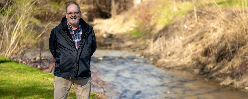 Doug Mulholland (featured researcher) posing in a stream 