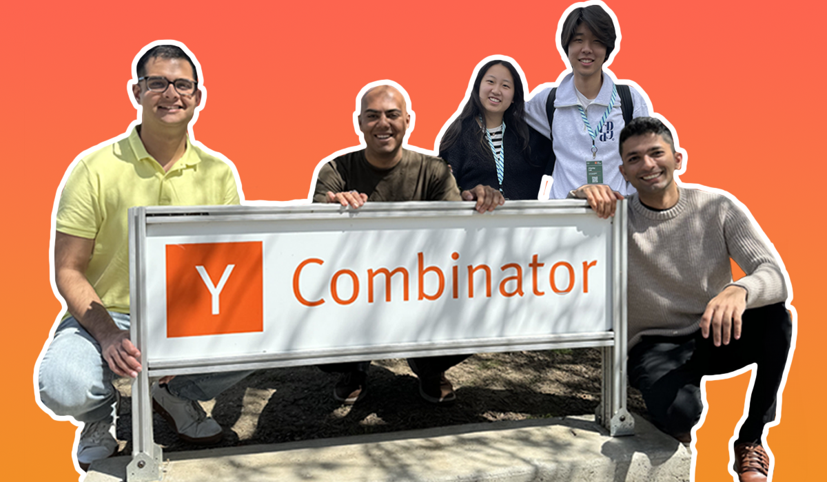 Photo of the winners in front of the y combinator sign. The background is an orange gradient colour