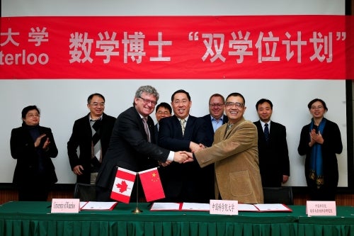 Representatives from the University of Waterloo and from the Chinese Academy of Sciences shaking hands