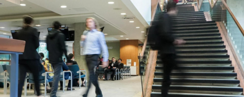 students walking in a busy room (students are preparing for job interviews). Students are blurred out to give an uneasy feeling