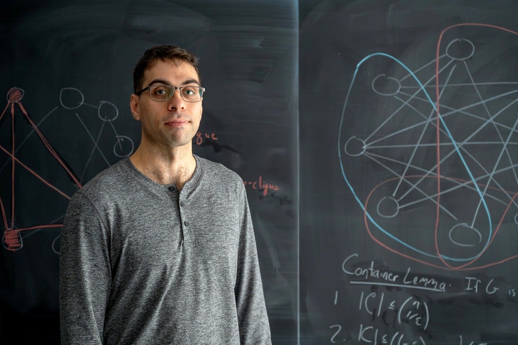 PhD candidate Cameron Seth at a blackboard