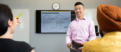 a male student presenting at the front of a class