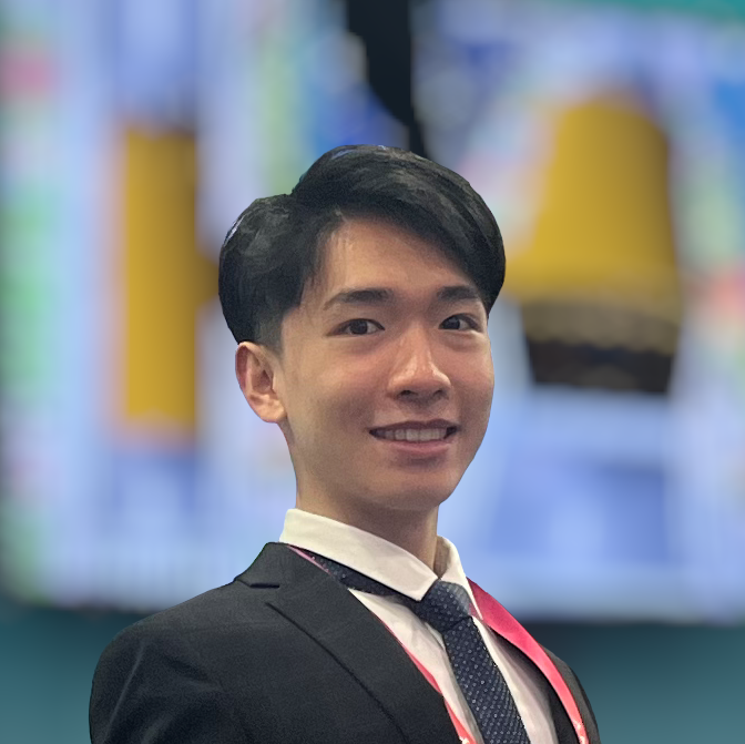 An Asian male in a suit posing in a blurry blue-yellow background