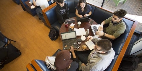 Birds eye view of five students studying at a round table