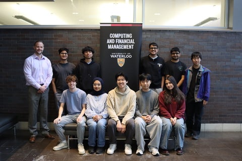 Group of students posing in front of a pop up banner reading Computing and Financial Management