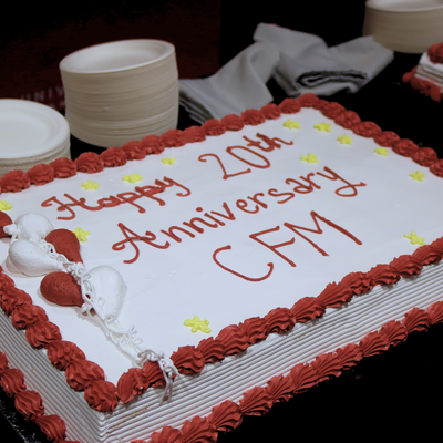 A red and white decorated cake that reads Happy 20th Anniversary, CFM