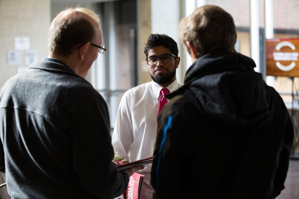 CFM-volunteer-talking-to-a-parent-and-his-son-about-the-program