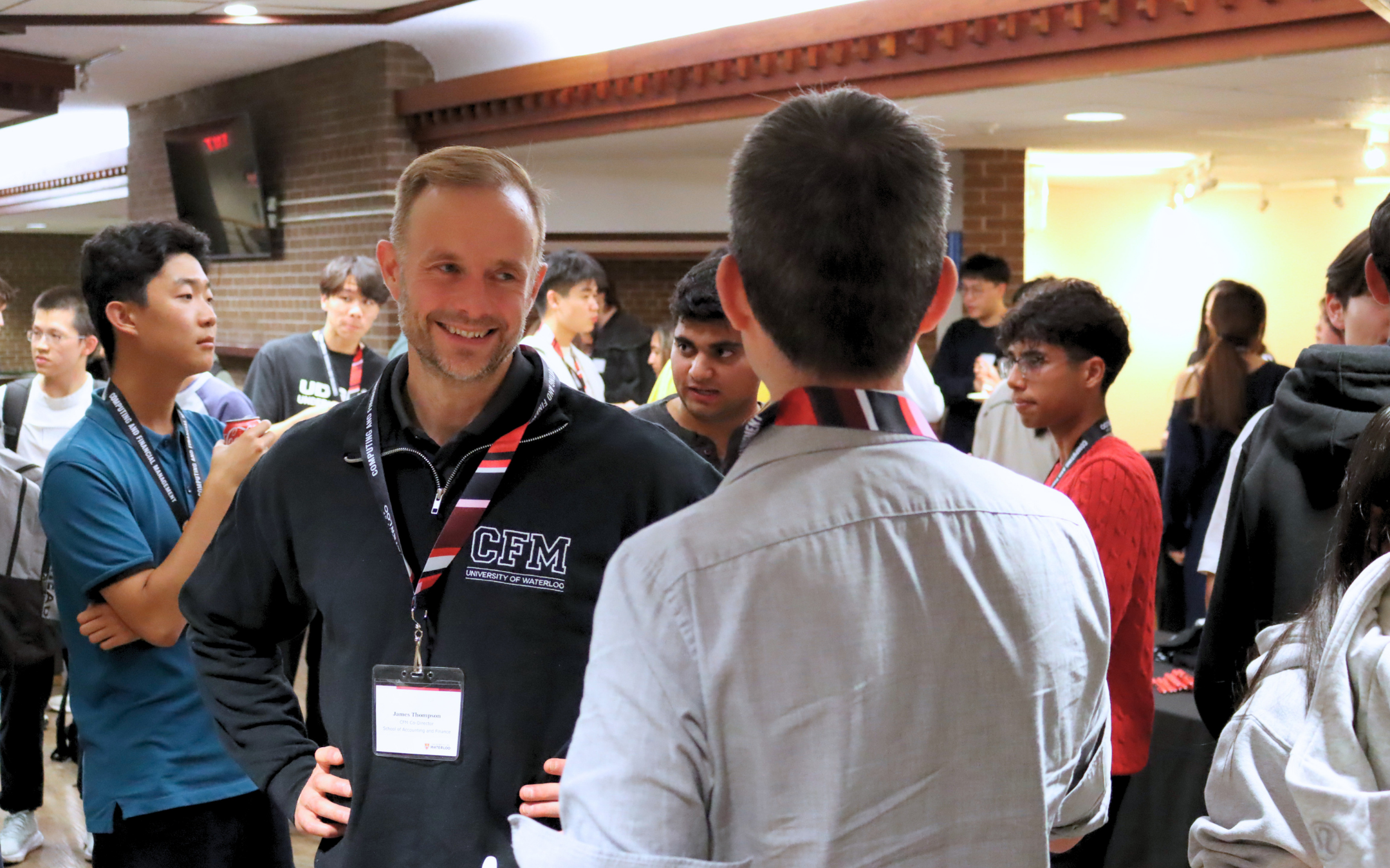 Professor James Thompson socializing with an alumnus