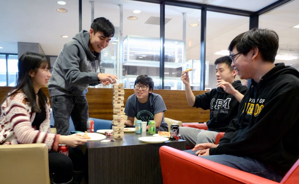 Four students playing Jenga